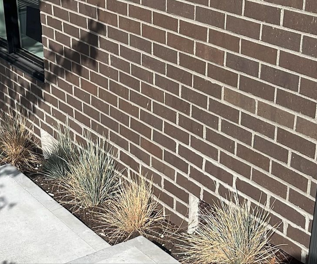 Close-up of dark brown brick veneer exterior.